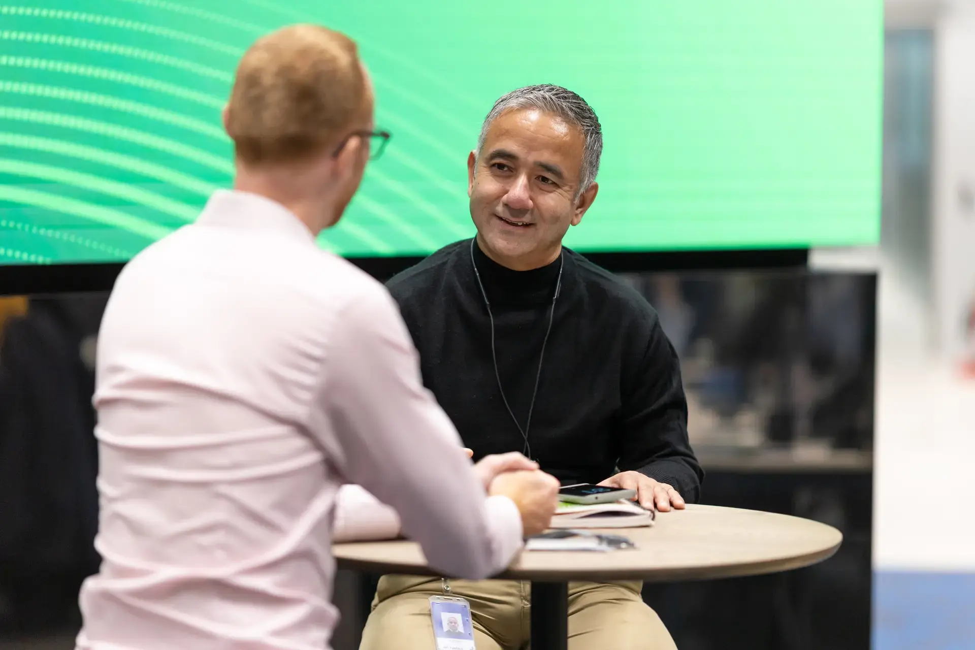 people_colleagues_sitting_and_talking_in_office_near_logo