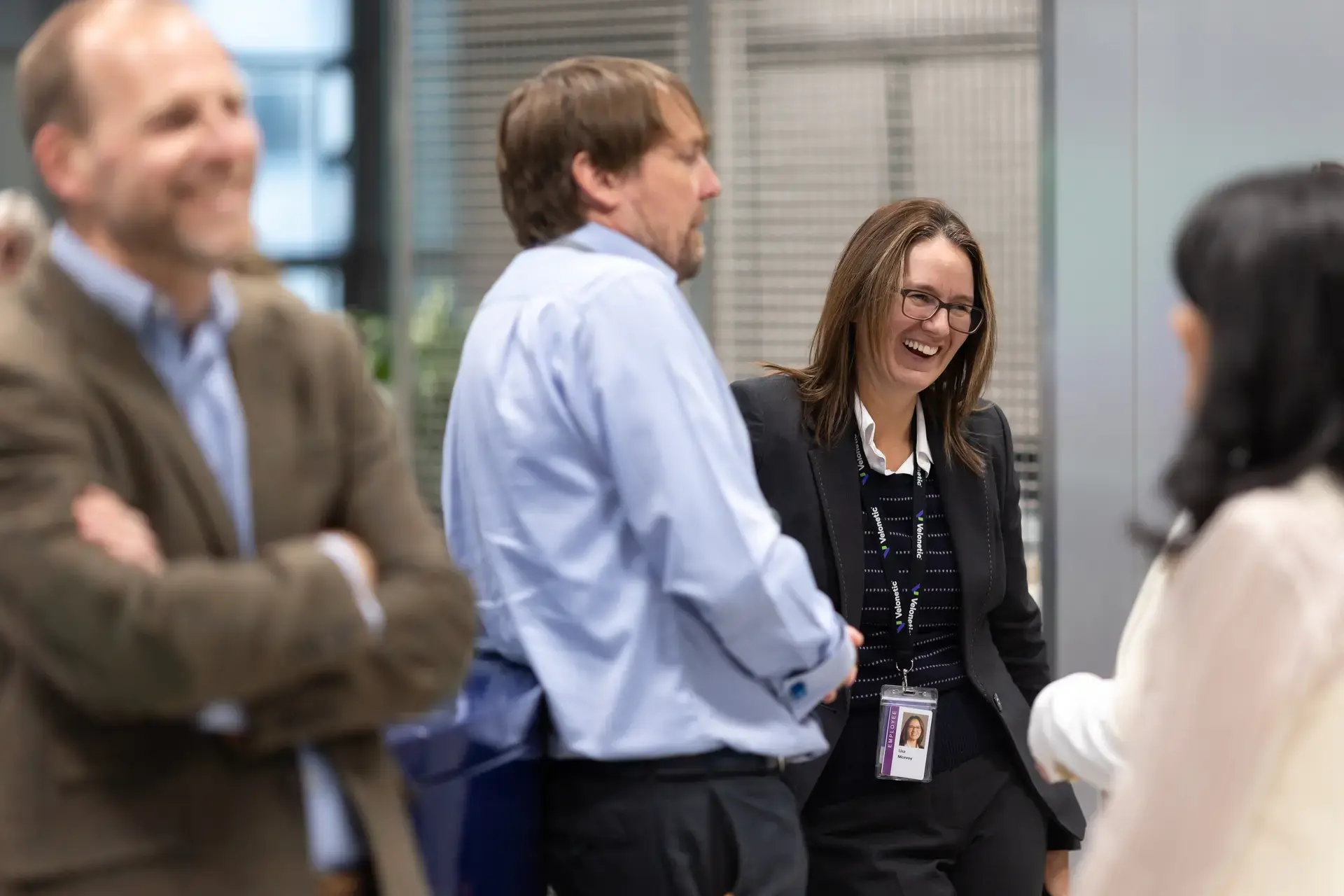 Colleagues standing laughing by coffee area