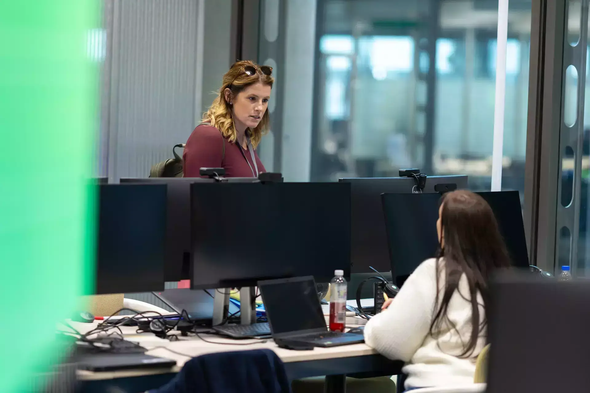 people_colleagues_talking_in_office_infront_of_laptop