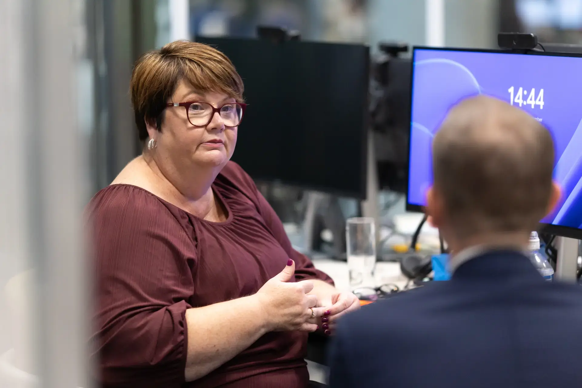 people_colleagues_talking_in_office_infront_off_laptop.